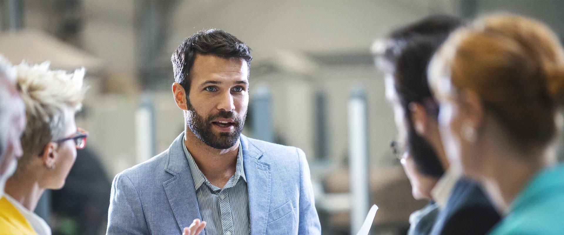 Professionnel entouré de son équipe de travail qui présente le plan de match