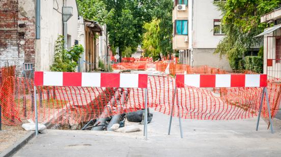 Travaux de canalisation dans le quartier de la ville, barrières routières et filets de sécurité autour du chantier