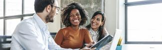 Deux femmes souriants et un homme avec regards complices