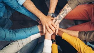 Groupe de personnes empilant des mains en cercle