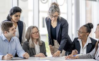 Groupe de spécialistes assis autour d'une table pour discuter de projets d'entreprise