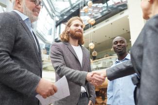 Hommes souriants qui se donnent la main illustrant la conclusion d'un contrat