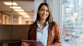 Femme souriante avec tablette illustrant l'écoute pour la prise de besoins