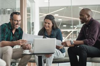 Services-conseils en administration publique : équipe en réunion stratégique analysant des documents de gestion et de performance organisationnelle.