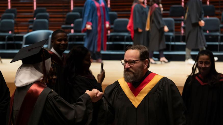 Sortie du cortège professeur qui félicite diplômée
